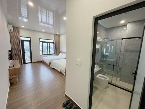 1 dormitorio con 1 cama y ducha acristalada en Phương Linh Hostel en Qua Phố