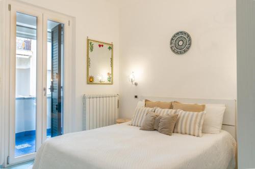 a white bedroom with a large white bed with pillows at Maiori Apartment by Marcel in Maiori