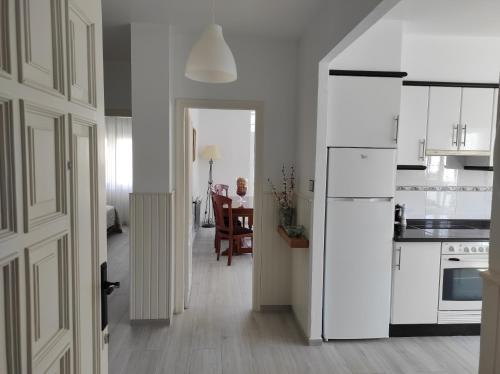 a kitchen with a white refrigerator and a table at Apartamento Area Pequena Ézaro in Ézaro