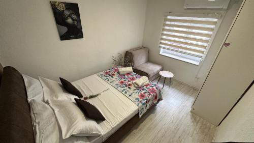a bedroom with a bed and a chair and a window at Villa Zigana in Mostar