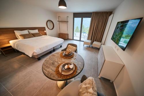 pokój hotelowy z łóżkiem i stołem w obiekcie Pure Thermal Residence w mieście Roquebillière