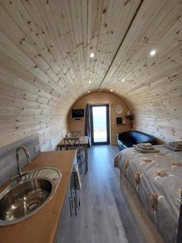 Cette chambre comprend un lit et un lavabo. dans l'établissement Loch Caroy Pods, à Ose