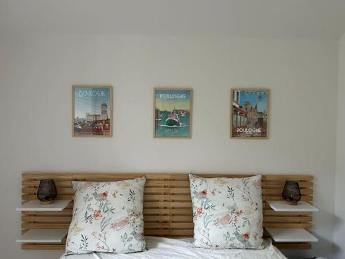 - une chambre avec trois affiches sur le mur au-dessus d'un lit dans l'établissement Aux remparts de la vieille ville - 4p, Parking, à Boulogne-sur-Mer