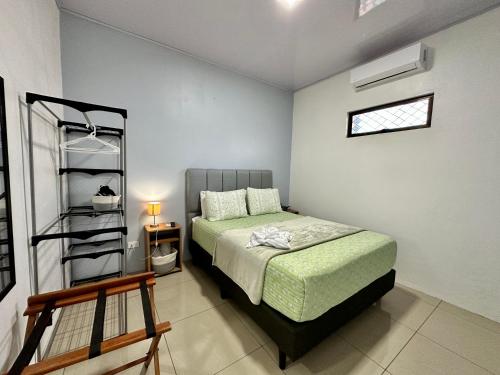 Un dormitorio con una cama y una estantería. en Oasis Arenal Villa Downtown Arenal Volcano View, en Fortuna