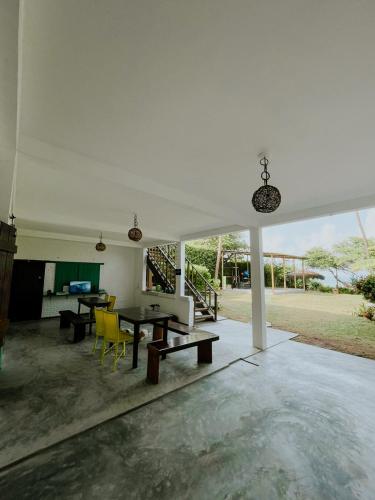 a living room with a table and yellow chairs at CASA VIDASURF in Pipa
