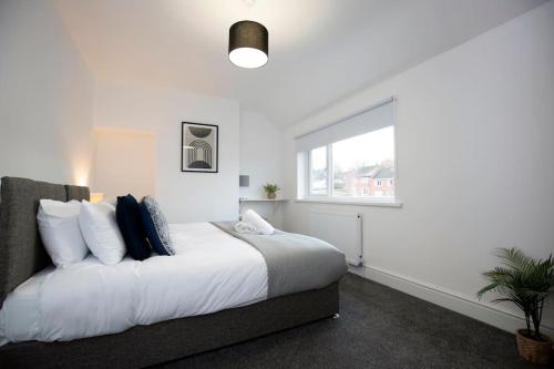 a white bedroom with a large bed and a window at HC Property - Cromwell Avenue in Newcastle upon Tyne