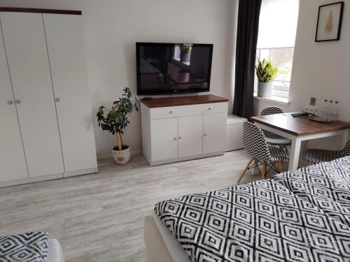 a bedroom with a bed and a tv and a table at Hotel Na Baste in Jablonec nad Nisou