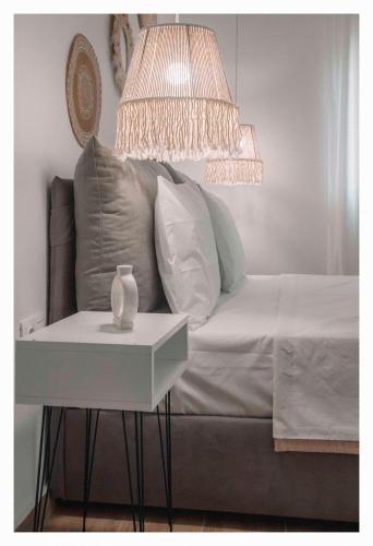 a bed with a side table and a lamp at Arias Apartments in Nea Kalikratia