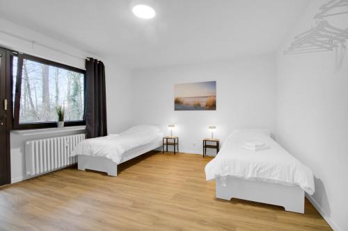 two beds in a white room with a window at Business-Apartment in Lippstadt in Lippstadt