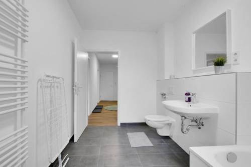a white bathroom with a sink and a toilet at Business-Apartment in Lippstadt in Lippstadt