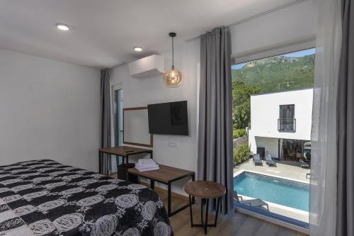 a hotel room with a bed and a swimming pool at Villa Visum Mare Tribus in Mošćenička Draga