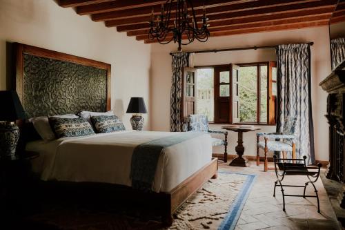 a bedroom with a large bed and a fireplace at Casa de Sierra Nevada, A Belmond Hotel, San Miguel de Allende in San Miguel de Allende
