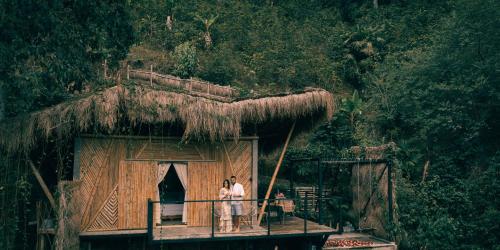 2 persone in piedi su un balcone di una capanna di ATTRAVERSIAMO BAMBOO HOUSE a Manizales