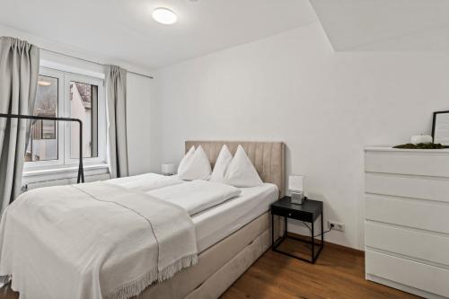 a white bedroom with a large bed and a window at Exklusive Unterkunft in RedBull-Ringnähe in Fohnsdorf