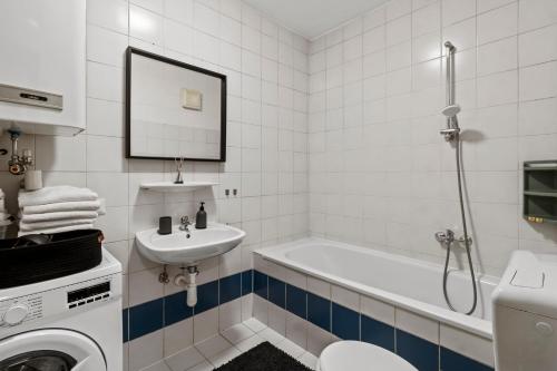 La salle de bains est pourvue d'une baignoire, d'un lavabo et d'un lave-linge. dans l'établissement Exklusive Unterkunft in RedBull-Ringnähe, à Fohnsdorf