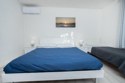 a bedroom with a bed with a blue blanket at Appartamento Levante a 300m dalla spiaggia in Golfo Aranci