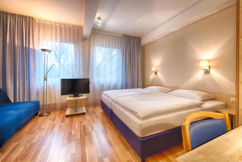 une chambre d'hôtel avec un lit et une télévision dans l'établissement enjoy hotel Berlin City Messe, à Berlin