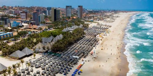 una vista aérea de una playa con sombrillas y el océano en VG Fun Praia do Futuro, en Fortaleza
