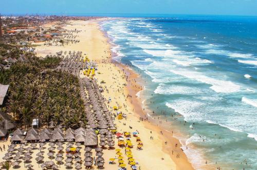 una vista aérea de una playa con sombrillas y el océano en VG Fun Praia do Futuro, en Fortaleza