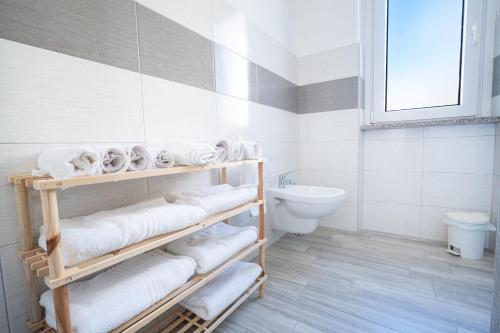 een badkamer met witte handdoeken en een toilet bij Appartamento Libeccio a 300m dalla spiaggia in Golfo Aranci