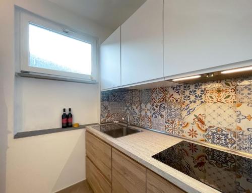a kitchen with a sink and a window at Casa Caretta con terrazza panoramica in Isola del Giglio