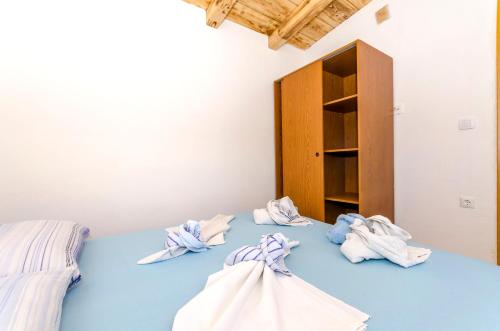 Una habitación con una cama con toallas. en Kuća Neven en Stomorska