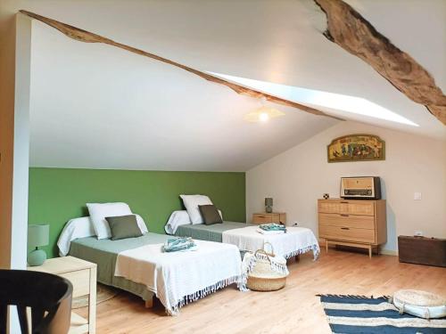 two beds in a room with green walls at Havre de Paix 40 in Pouillon