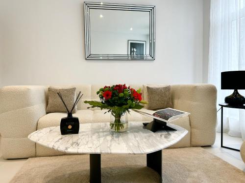 sala de estar con sofá y mesa con un jarrón de flores en Residence phoenix AP2, en Mons