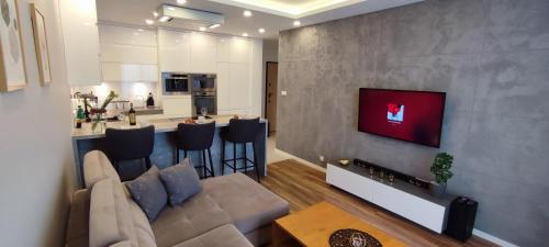 a living room with a couch and a kitchen at Gold Apartments Penthouse in Rzeszów