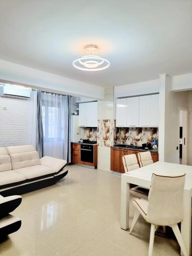 sala de estar con mesa blanca y sillas en Apartament Aqua - Endless Summer Mamaia Nord Apartaments, en Mamaia Nord – Năvodari