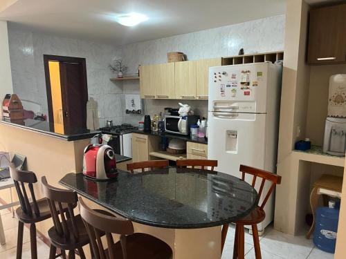 a kitchen with a table with chairs and a refrigerator at AP Completo Tabatinga in Nísia Floresta