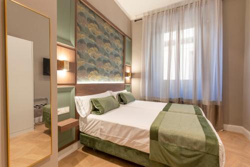 ein Schlafzimmer mit einem Bett und einem großen Fenster in der Unterkunft BiBo Suites Palacio de Portago in Granada