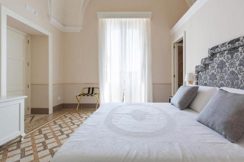 a bedroom with a large bed and a window at Palazzo Fasti in Casarano