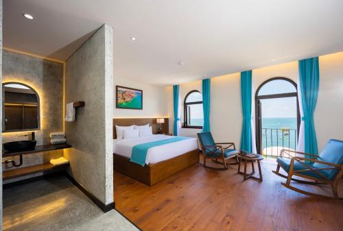 a hotel room with a bed and two chairs at Fella Hotel Phu Quoc - Free Hon Thom Island Waterpark Cable Car in Phu Quoc