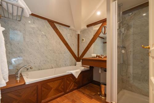 La salle de bains est pourvue d'une baignoire et d'une douche. dans l'établissement LA FOLIE, à Forges-les-Eaux