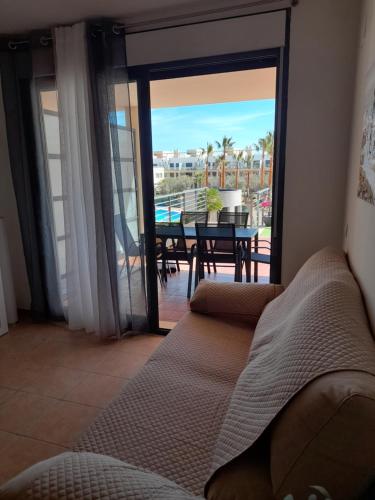 uma sala de estar com um sofá e vista para uma mesa em Piso de lujo - descansar y trabajar en Golf Panoramica para 4 pers - internet fibra GRATIS em Sant Jordi