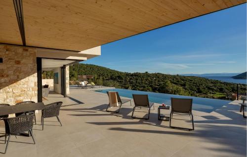 a group of chairs sitting on a patio next to a pool at Issa Hills Villa in Vis