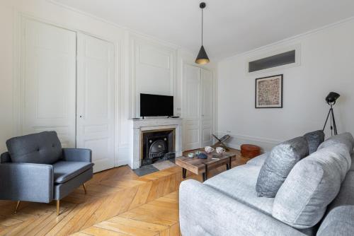 un salon avec un canapé et une cheminée dans l'établissement Gusman - Longue durée dans le 2ème arrondissement, à Lyon