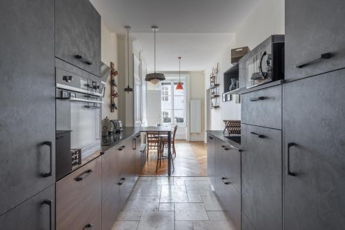 une cuisine avec des appareils en acier inoxydable et une table dans l'établissement Gusman - Longue durée dans le 2ème arrondissement, à Lyon