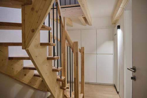 a wooden staircase in a room with white walls at Haus Fünf mit 2 Apartments und Studio-Loft mit Terrasse in Melk