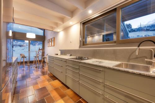 a kitchen with a sink and a large window at Le Contemporain - Chalet vue sur le Mont Blanc in Saint-Gervais-les-Bains