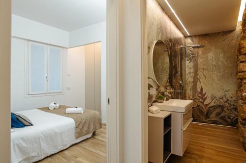 een slaapkamer met een bed, een wastafel en een spiegel bij Un Nido Sull'Arena - Royal Welcome in Verona
