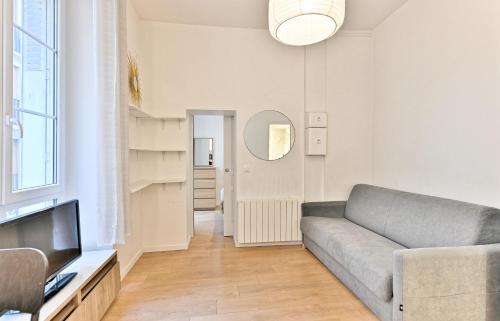 un salon avec un canapé et une télévision dans l'établissement Appartement au cœur du Marais - III, à Paris
