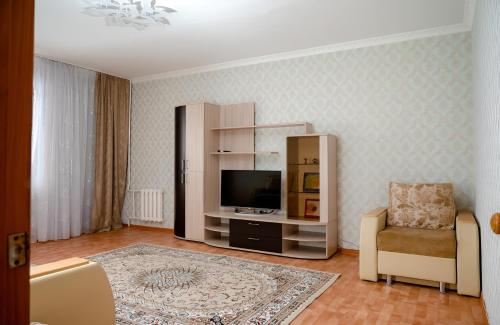 un soggiorno con TV e sedia di 2 комнатная квартира, по суточно, напротив ТД Сырымбет a Kökşetaw