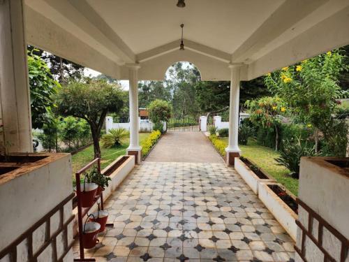 een lege loopbrug naar een huis met een veranda bij Narmada Holiday Home in Ooty