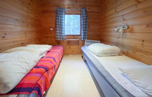 1 dormitorio con 2 camas en una cabaña de madera en Stuga 7, en Nybro