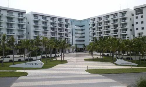 a walkway in front of a building with palm trees at Playa Blanca Doble in Río Hato
