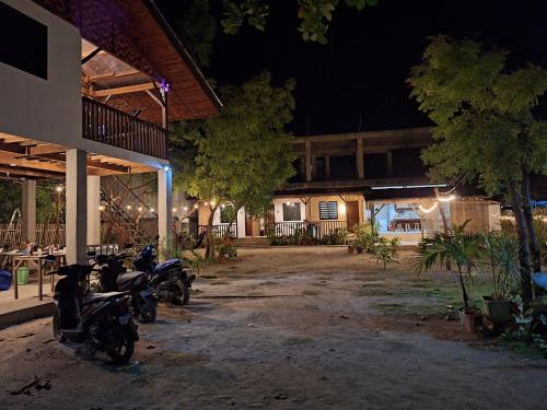 due moto parcheggiate fuori da un edificio di notte di Basilia Guest House a Isola di Bantayan