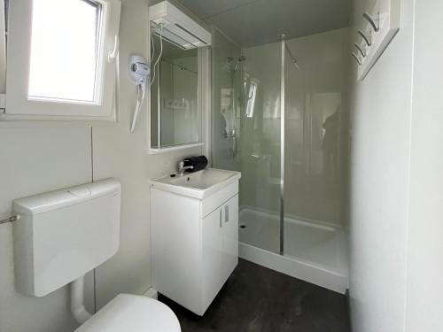 biała łazienka z toaletą i prysznicem w obiekcie Thermal Camping Zalakaros w Zalakaros