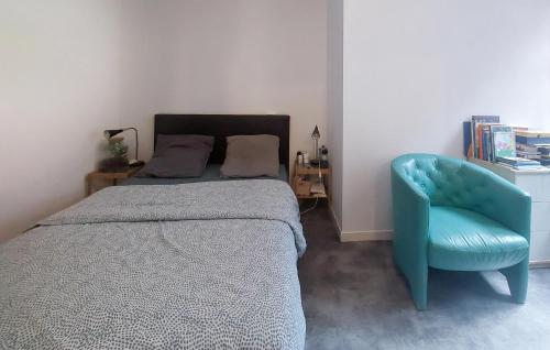 a bedroom with a bed and a blue chair at 3 Bedroom Lovely Home In Dunkerque in Dunkerque